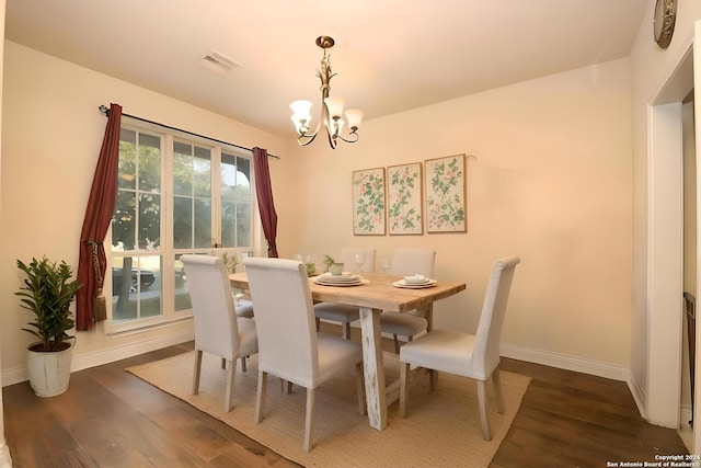 dining room featuring dark hardwood / wood-style floors and an inviting chandelier