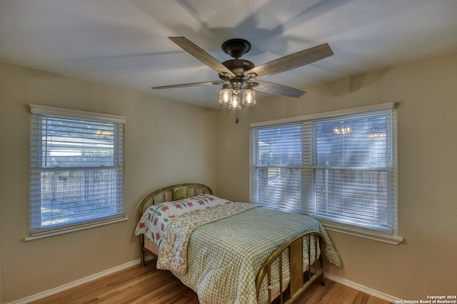 bedroom featuring multiple windows, ceiling fan, and light hardwood / wood-style floors