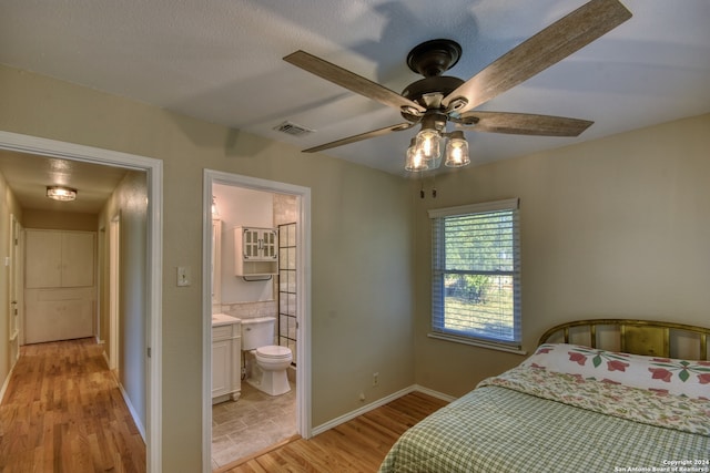 bedroom featuring ensuite bathroom, ceiling fan, and light hardwood / wood-style floors