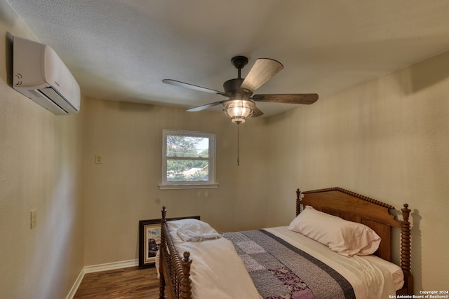 bedroom with a wall unit AC, ceiling fan, and dark wood-type flooring