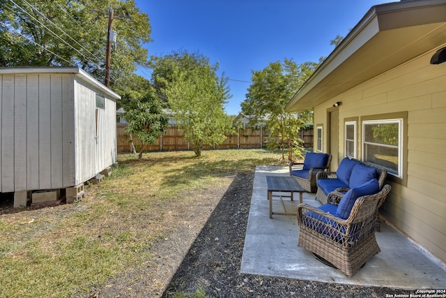 view of yard featuring an outdoor living space, a patio area, and a shed