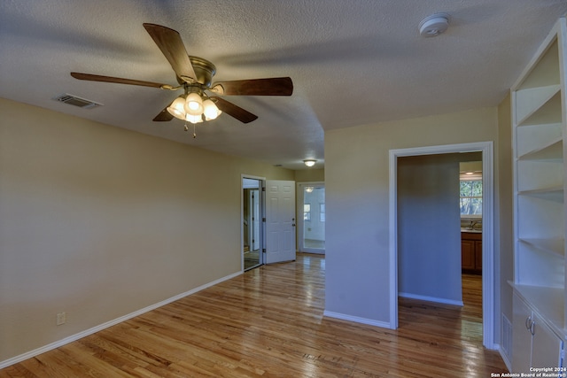 spare room featuring ceiling fan, a textured ceiling, and light hardwood / wood-style flooring