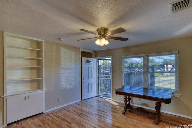 dining area featuring built in shelves, ceiling fan, plenty of natural light, and light wood-type flooring