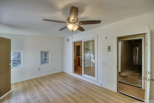 spare room featuring ceiling fan, a textured ceiling, and light wood-type flooring