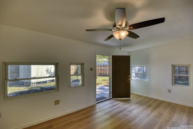 empty room featuring ceiling fan, light hardwood / wood-style floors, and vaulted ceiling