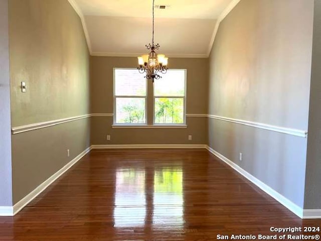 spare room with a notable chandelier, crown molding, dark wood-type flooring, and vaulted ceiling