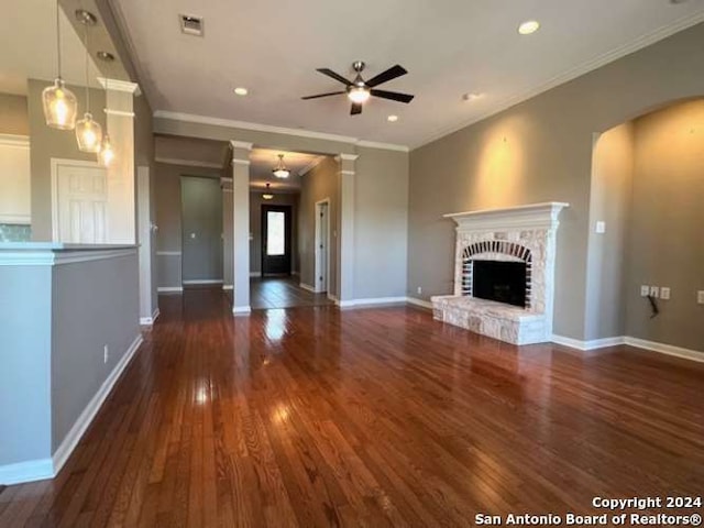 unfurnished living room with crown molding, a fireplace, ceiling fan, and dark hardwood / wood-style floors