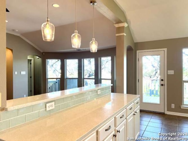 kitchen featuring dark tile patterned flooring, decorative light fixtures, a healthy amount of sunlight, and vaulted ceiling