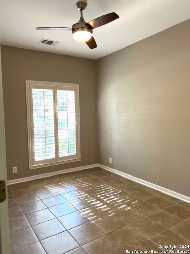 spare room with tile patterned flooring and ceiling fan