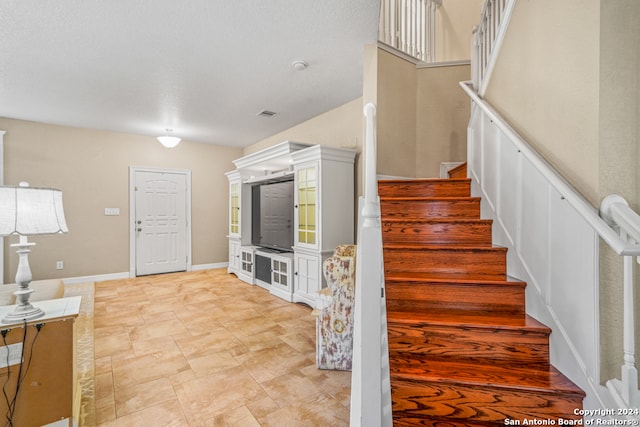 staircase featuring a textured ceiling