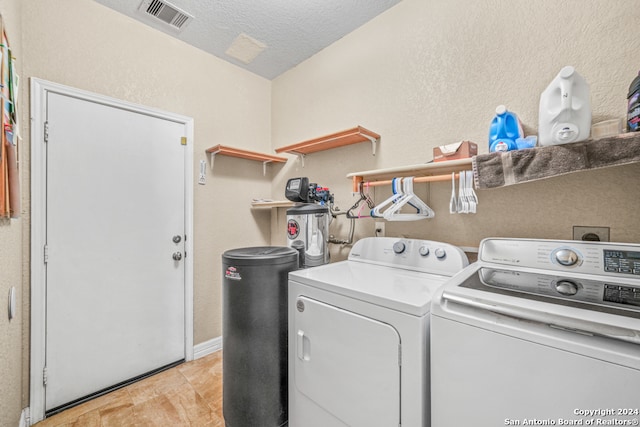 laundry room featuring a textured ceiling and washing machine and clothes dryer