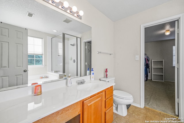 bathroom featuring walk in shower, tile patterned floors, a textured ceiling, toilet, and vanity