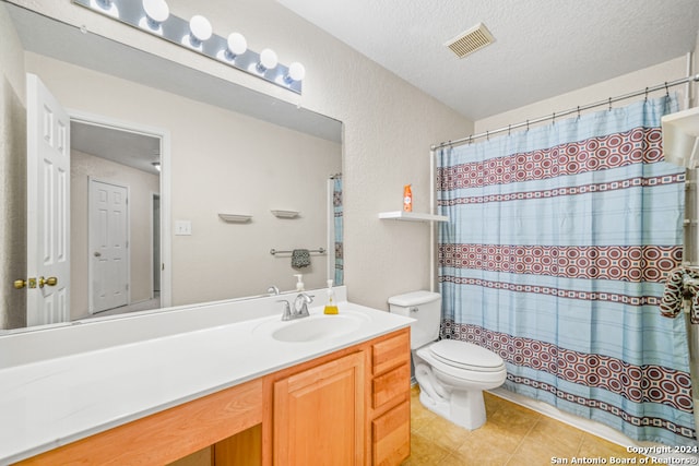 bathroom with vanity, tile patterned flooring, toilet, a textured ceiling, and curtained shower