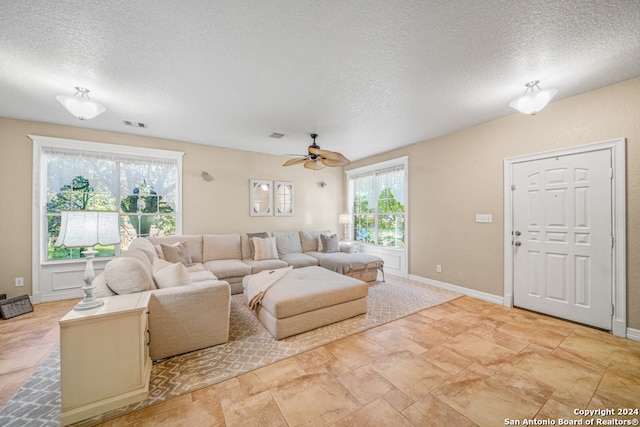 living room featuring a textured ceiling and ceiling fan