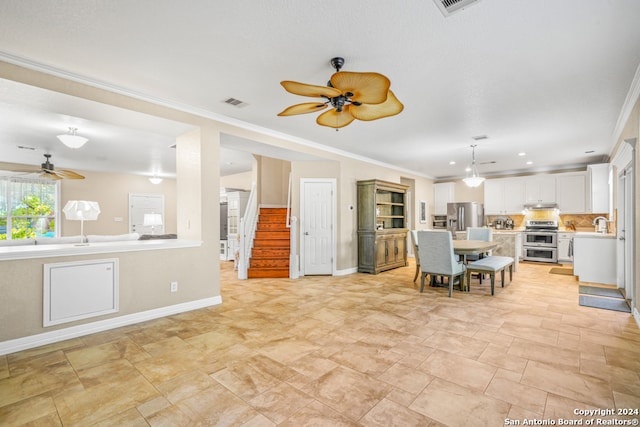 interior space featuring appliances with stainless steel finishes, tasteful backsplash, white cabinetry, and ornamental molding