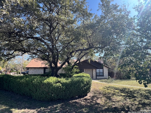 view of side of home featuring a yard and stone siding