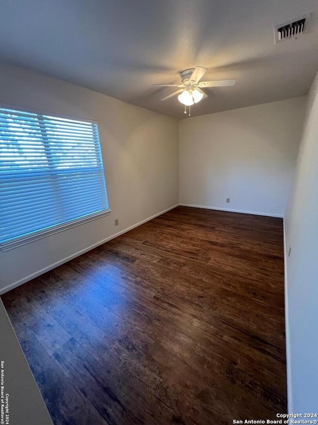 unfurnished room with ceiling fan and dark hardwood / wood-style flooring