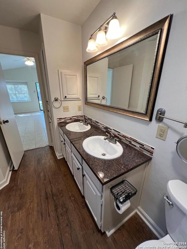 bathroom featuring ceiling fan, toilet, vanity, and hardwood / wood-style flooring