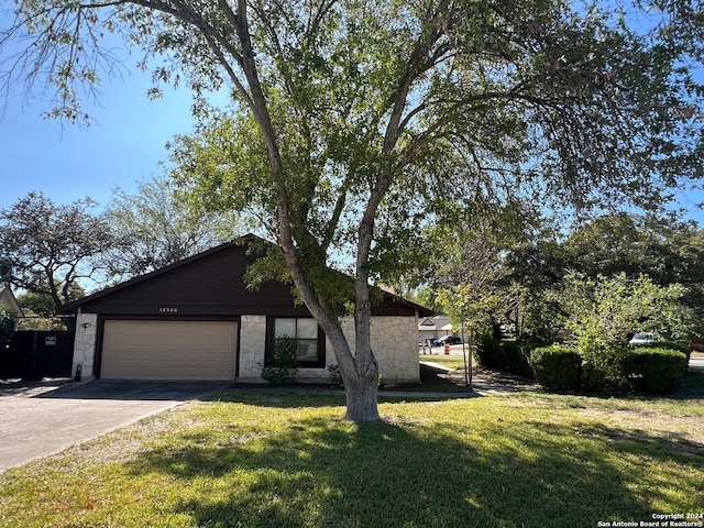 ranch-style home with a front lawn and a garage