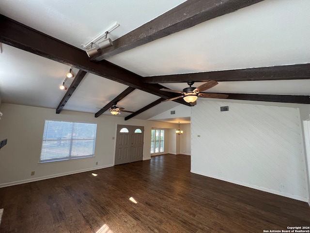 unfurnished living room with ceiling fan with notable chandelier, lofted ceiling with beams, dark hardwood / wood-style floors, and track lighting