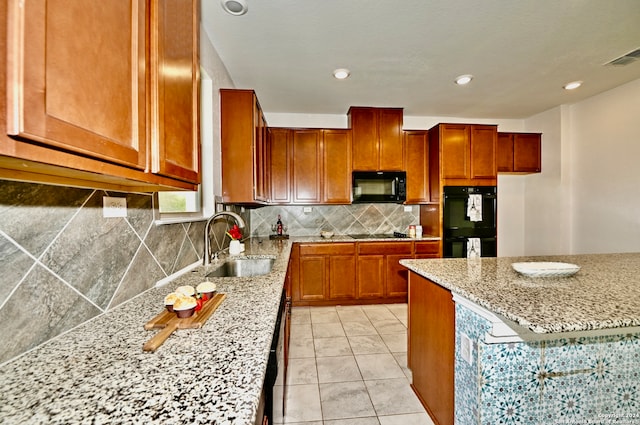 kitchen featuring black appliances, light stone countertops, sink, and light tile patterned floors