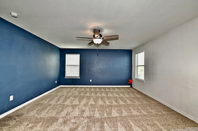 spare room with ceiling fan, carpet, and a textured ceiling