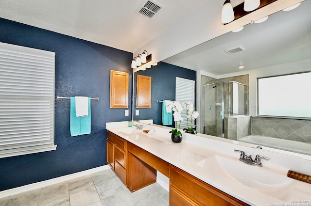 bathroom featuring plus walk in shower, vanity, and tile patterned floors