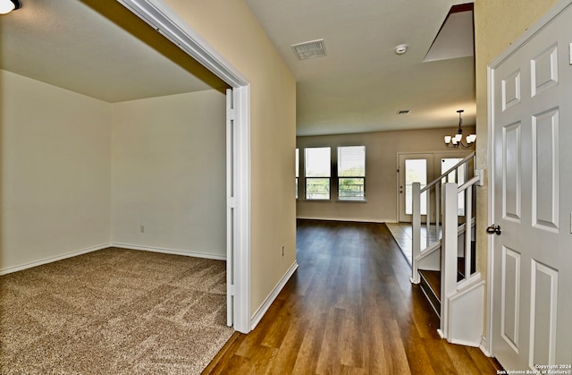 hall featuring dark hardwood / wood-style floors and an inviting chandelier