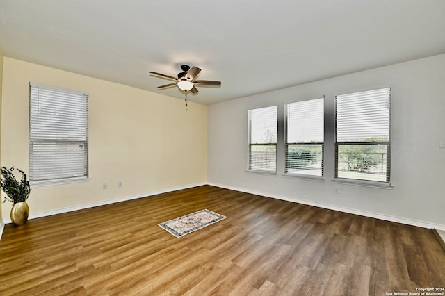 empty room with ceiling fan and hardwood / wood-style floors