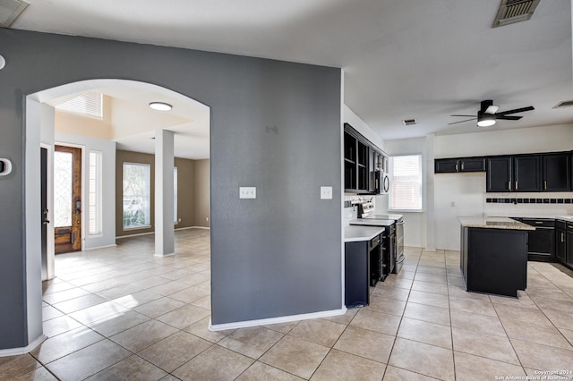 268 Fawn Rdg, Cibolo, TX 78108 - kitchen featuring stainless steel electric range, arched walkways, dark cabinetry, light tile patterned floors, and a ceiling fan