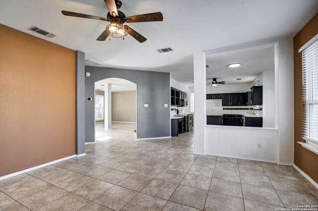 268 Fawn Rdg, Cibolo, TX 78108 - unfurnished living room with a ceiling fan, arched walkways, light tile patterned floors, and baseboards