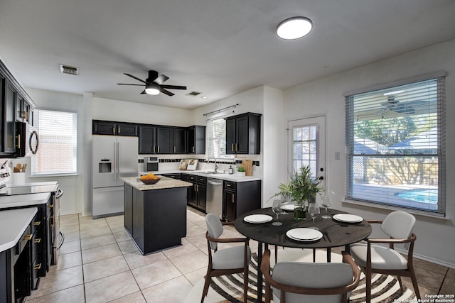 268 Fawn Rdg, Cibolo, TX 78108 - kitchen with stainless steel appliances, a sink, dark cabinetry, a center island, and light countertops