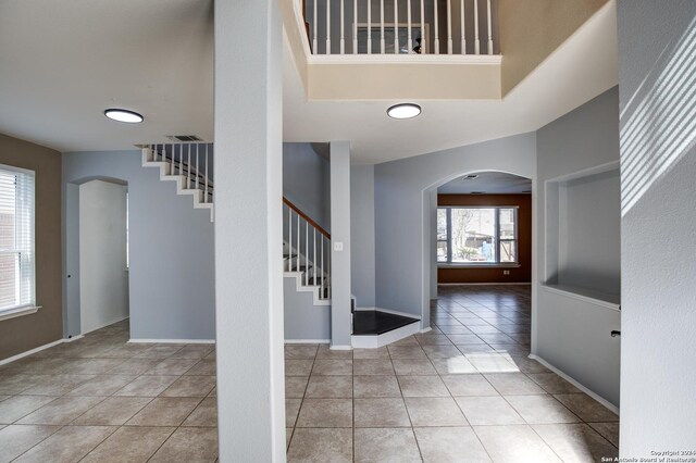 268 Fawn Rdg, Cibolo, TX 78108 - tiled entryway with arched walkways, stairs, baseboards, and a high ceiling