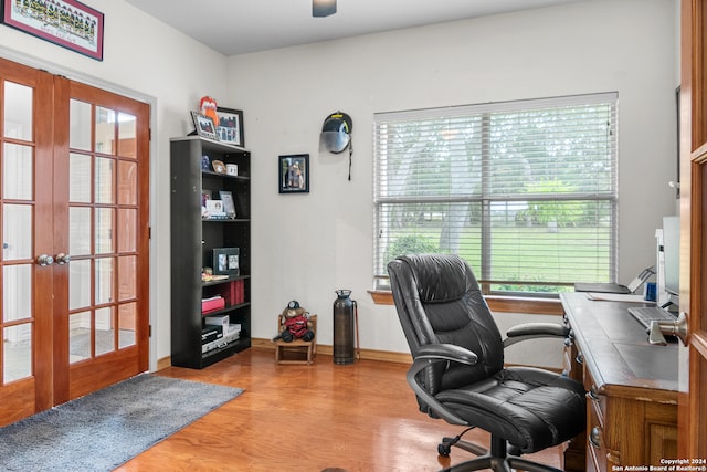 home office featuring plenty of natural light, light hardwood / wood-style floors, and french doors