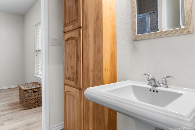 bathroom featuring hardwood / wood-style floors, sink, and walk in shower