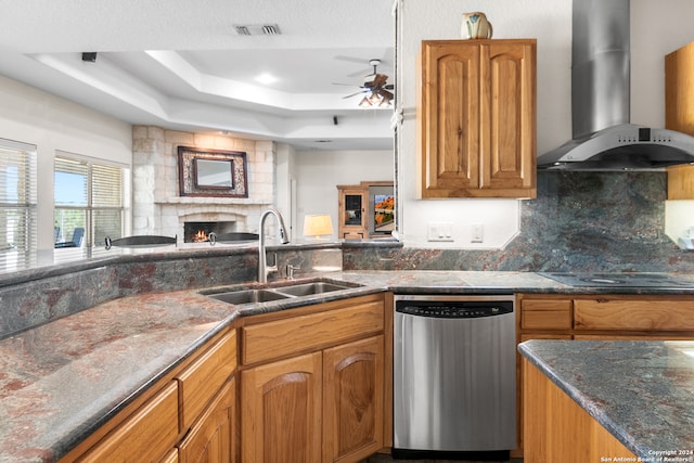 kitchen with wall chimney range hood, sink, stainless steel dishwasher, ceiling fan, and black electric cooktop