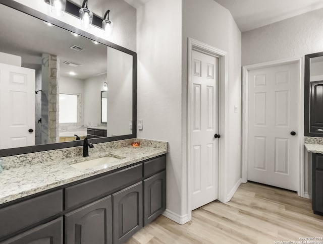 bathroom with separate shower and tub, vanity, and wood-type flooring