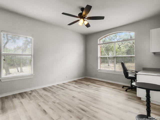 unfurnished office featuring light wood-type flooring and ceiling fan