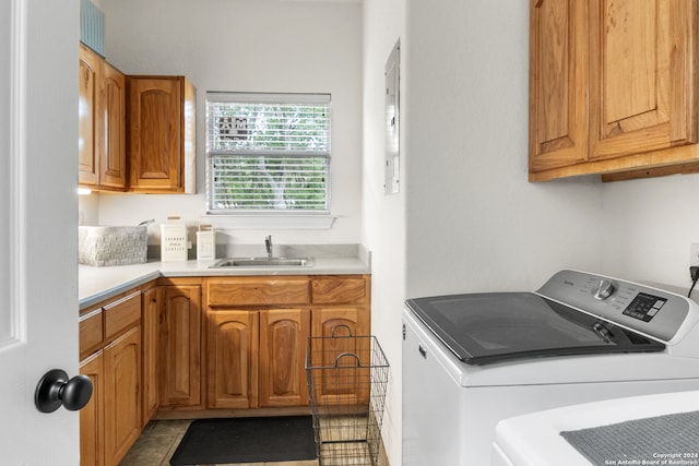 laundry area featuring washer and clothes dryer, tile patterned floors, sink, and cabinets