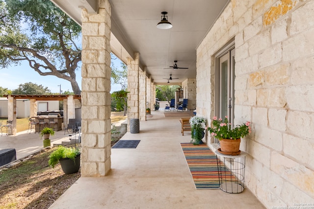 view of patio with exterior bar and ceiling fan