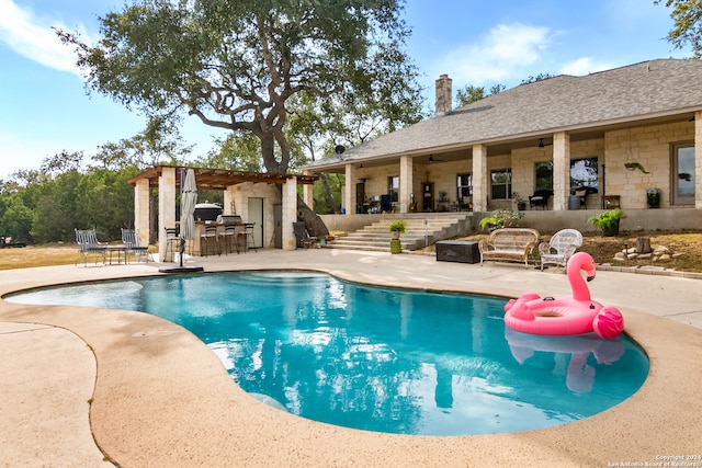 view of pool with a patio area, exterior bar, and an outdoor kitchen