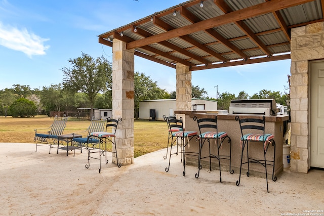 view of patio with area for grilling and a bar