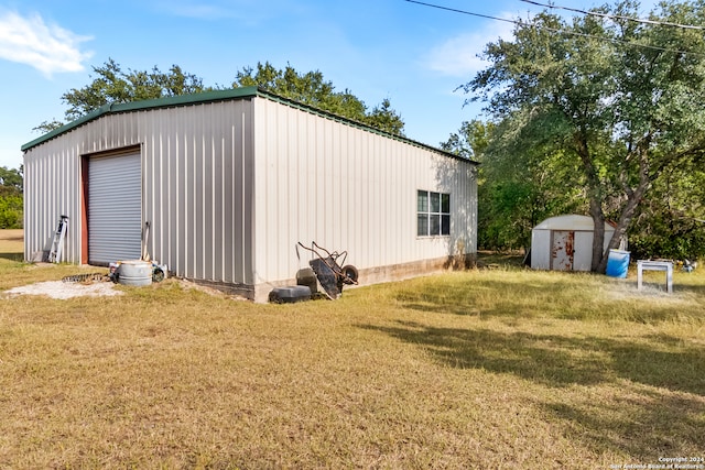 view of outdoor structure with a lawn and a garage