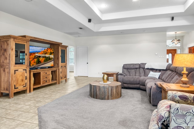 tiled living room with a tray ceiling and a chandelier