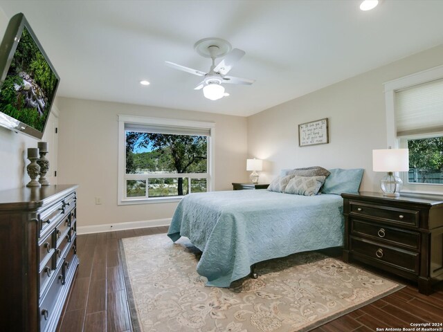 bedroom with dark hardwood / wood-style floors and ceiling fan