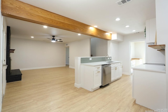 kitchen featuring light wood finished floors, visible vents, dishwasher, white cabinetry, and a sink