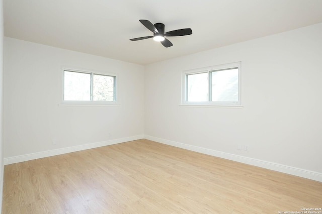 empty room with baseboards, a ceiling fan, and light wood finished floors