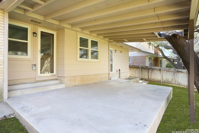 view of patio featuring visible vents, entry steps, and fence