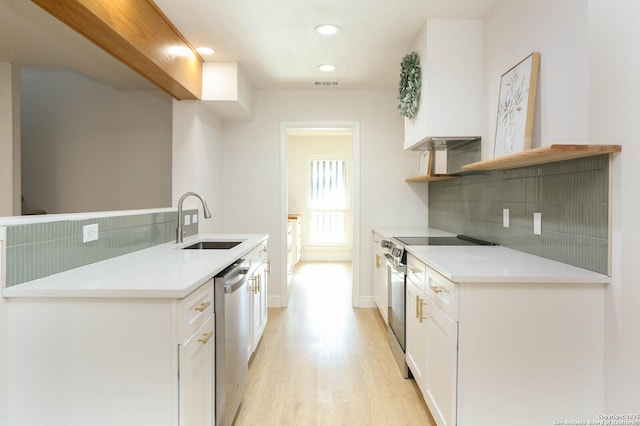 kitchen featuring visible vents, a sink, open shelves, stainless steel appliances, and light wood finished floors