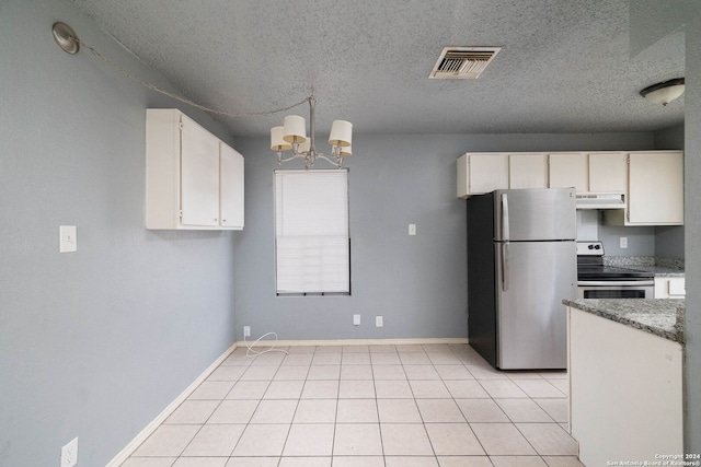 kitchen with light tile patterned floors, stainless steel appliances, a textured ceiling, and a notable chandelier